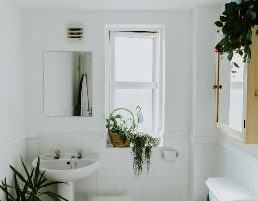 A clean, light-filled bathroom with white tiled walls, a basin and natural greenery — an example of the modular bathrooms we design and install.